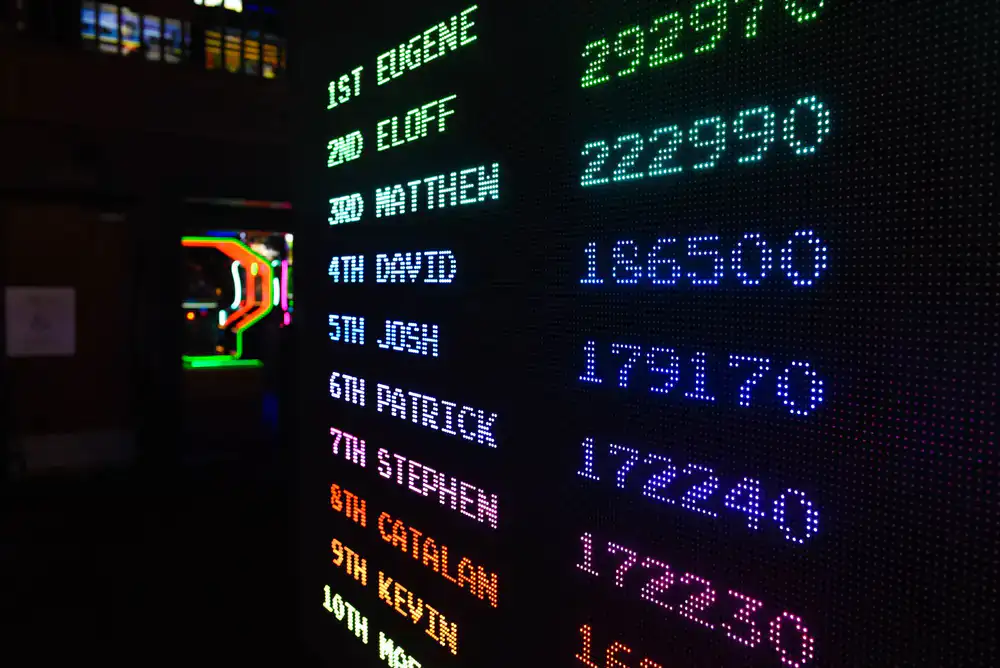 Staff member holding a clipboard verifying an arcade score